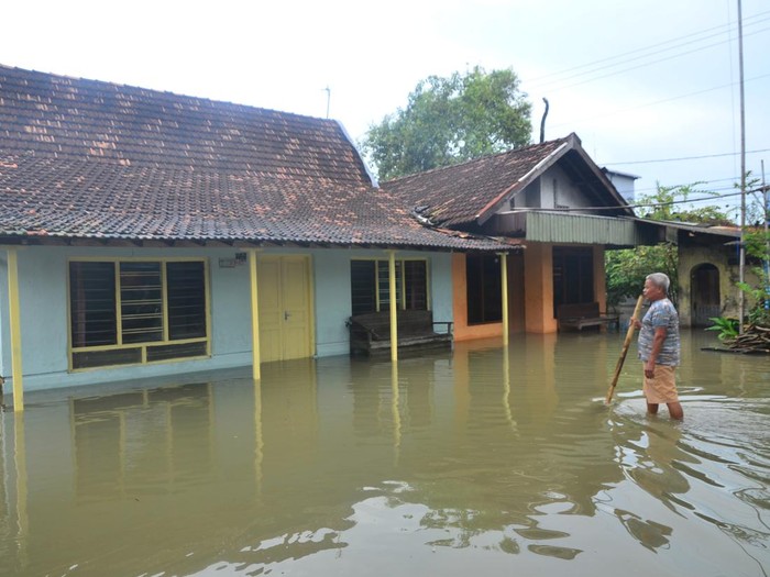 Pengendara sepeda motor melintas di jalan yang tergenang air di Desa Tanjungkarang, Jati, Kudus, Jawa Tengah, Senin (28/2/2022). Akibat curah hujan yang tinggi serta drainase yang buruk menyebabkan puluhan rumah serta beberapa jalan utama di desa itu terendam banjir. ANTARA FOTO/Yusuf Nugroho/tom.