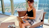 Bekerja di kafe dengan pemandangan gedung-gedung tinggi juga dilakoni. Tentunya secangkir minuman hangat tak boleh ketinggalan menemaninya.Foto: Instagram/anastasiia.lenna