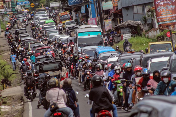 Kepadatan kendaraan di jalur wisata Puncak, Cisarua, Kabupaten Bogor, Jawa Barat, Senin (28/2/2022). Tingginya volume kendaraan wisatawan saat libur Isra Miraj Nabi Muhammad SAW menyebabkan terjadinya kepadatan di jalur wisata Puncak Bogor sehingga Polres Bogor memberlakukan sistem satu arah serta pengalihan arus lalu lintas untuk mengurai kepadatan kendaraan. ANTARA FOTO/Yulius Satria Wijaya/tom.