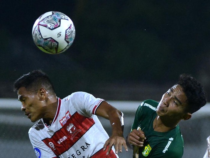 Pesepak bola Madura United Asep Berlian (kiri) berebut bola dengan pesepak bola Persebaya Surabaya Marselino Ferdinan (kanan) dalam pertandingan Liga 1 di Stadion I Gusti Ngurah Rai, Denpasar, Bali, Senin (28/2/2022). ANTARA FOTO/Fikri Yusuf/tom.