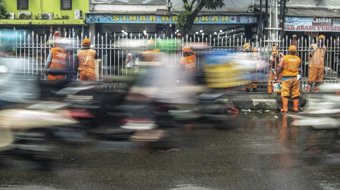 Pagar Pembatas Jalan di Kramat Jati Dicat Ulang Biar Kinclong Sejumlah Petugas Pengelolaan Prasarana dan Sarana Umum (PPSU) atau pasukan orange mengecat pagar pembatas jalan di kawasan Kramat Jati, Jakarta, Minggu (27/2/2022). Pengecatan dilakukan sebagai perawatan rutin untuk menjaga pembatas jalan yang sudah mulai pudar dan kotor agar tetap bersih. ANTARA FOTO/Muhammad Adimaja/aww.