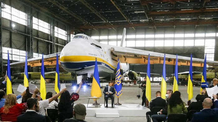 Ukrainian President Volodymyr Zelenskyy speaks to the media during a news conference with the worlds largest airplane, Ukrainian Antonov An-225 Mriya in the background at the Antonov aircraft factory in Kyiv, Ukraine, Thursday, May 20, 2021. (AP Photo/Efrem Lukatsky)
