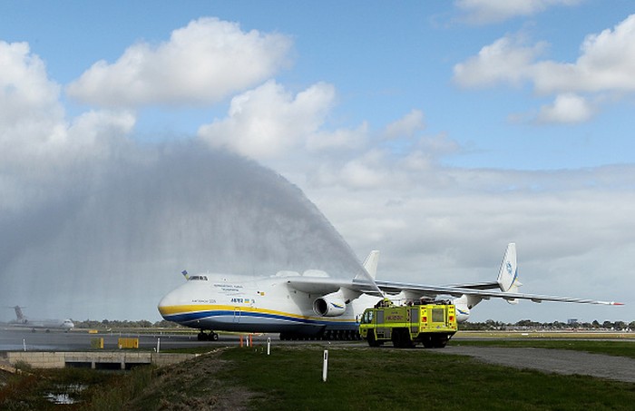Penampakan Pesawat Terbesar Dunia Sebelum Hancur Diserang Rusia PERTH, AUSTRALIA - MAY 15: A ground staff member signals to pilots after the arrival of the Antonov AN-225 Mriya at Perth International airport on May 15, 2016 in Perth, Australia. The Ukrainian cargo plane is 84 metres long and has a wingspan of 88.4 metres and is in Perth to (Photo by Paul Kane/Getty Images)