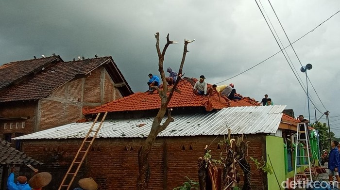 Warga memperbaiki atap rumah yang tersapu puting beliung di Jepara, Senin (28/2/2022).