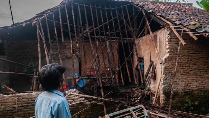 Seorang warga melihat kondisi bagian rumah yang roboh akibat pergerakan tanah di Desa Curug Panjang, Lebak, Banten, Senin (28/2/2022). Rumah rusak akibat pergerekan tanah yang terjadi daerah itu bertambah menjadi 50 rumah seiring dengan seringnya hujan deras mengguyur kawasan tersebut. ANTARA FOTO/Muhammad Bagus Khoirunas/tom.