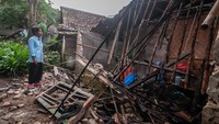 Seorang warga melihat kondisi bagian rumah yang roboh akibat pergerakan tanah di Desa Curug Panjang, Lebak, Banten, Senin (28/2/2022).