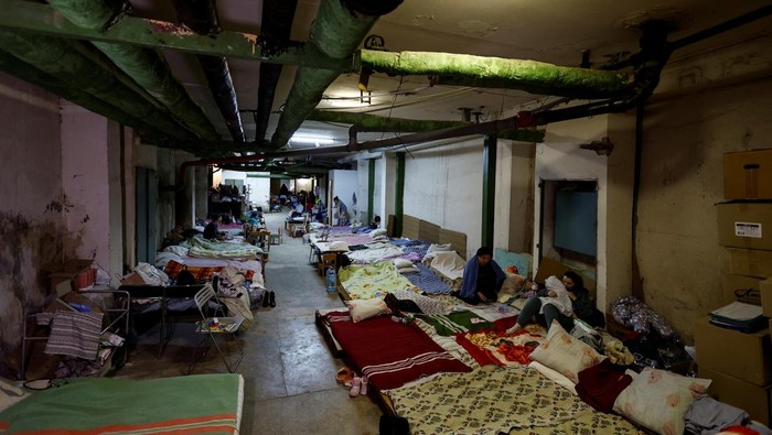 UKRAINE-CRISIS/KYIV-HOSPITAL A woman with a baby sits on a mattress in one of the shelters of Okhmadet Children's Hospital, as Russia's invasion of Ukraine continues, in Kyiv, Ukraine February 28, 2022. REUTERS/Umit Bektas