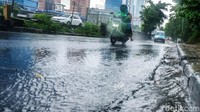 Sejumlah pemotor di jalanan menggunakan jas hujan untuk menghindari basah.