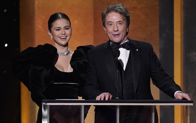 Selain tak memakai alas kaki, yang juga menarik perhatian dari momen Selena Gomez di SAG Awards adalah saat dia bercanda tentang botox saat mengobrol dengan Martin Short sebelum membacakan pemenang aktris pendukung terbaik. “Aku sulit mengekspresikan kegembiraanku karena botox ku masih baru,” kata Martin. “Punyaku juga,” balas Selena. Foto: Chris Pizzello/Invision/AP/Chris Pizzello