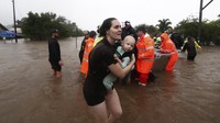 Proses evakuasi warga yang terdampak banjir masih terus dilakukan. Tim penyelamat mengevakuasi warga dengan menggunakan perahu karet. (AP Photo/Jason OBrien).