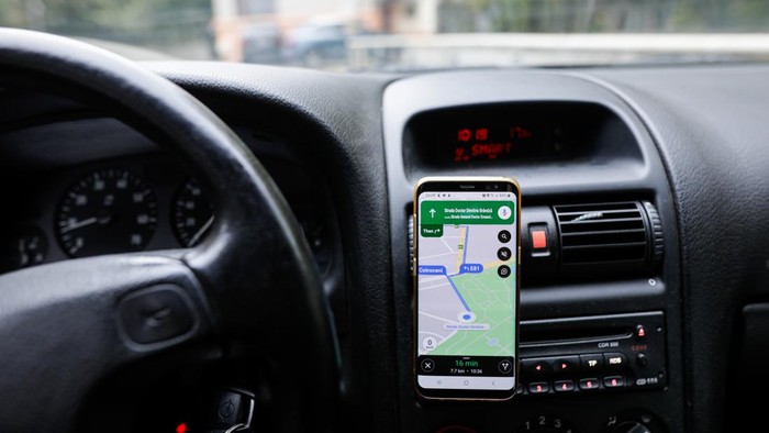 Bucharest, Romania - October 25, 2020: Shallow depth of field (selective focus) image with the Google Maps app on a mobile device in a car.