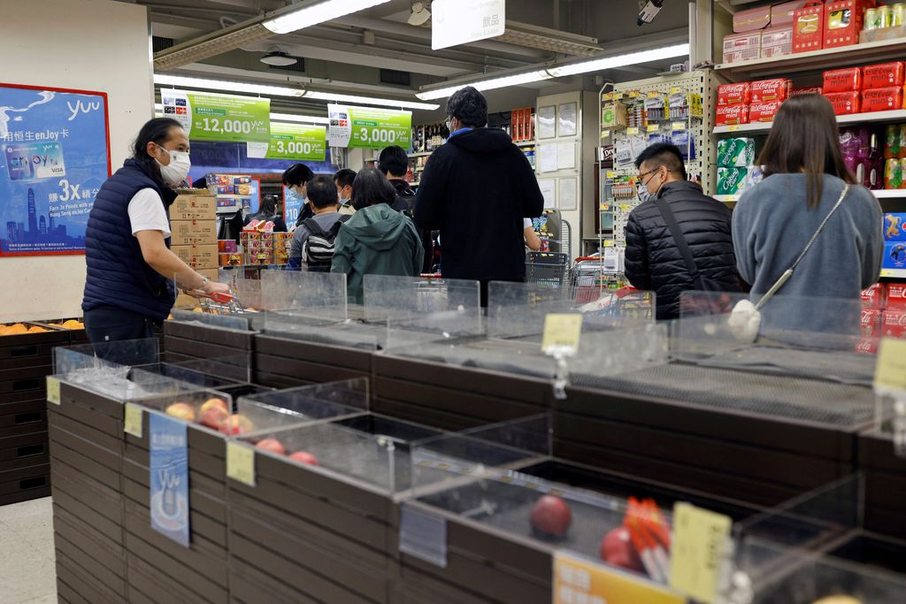 Customers wearing masks shop in front of partially empty shelves at a supermarket during the coronavirus disease (COVID-19) outbreak in Hong Kong, China February 28, 2022. REUTERS/Tyrone Siu