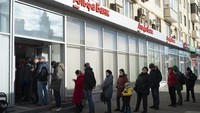 Sejumlah warga mengantre untuk menarik uang di ATM yang berada di Bank Alfa, Moskow, Rusia, Minggu (27/2/2022). AP Photo/Victor Berzkin.