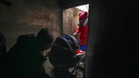 Sepasang suami istri membawa bayinya memasuki tempat aman saat terjadi baku tembak di luar kota Mariupol, Ukraina, Kamis, (24/2/2022) (AP Photo/Sergei Grits)