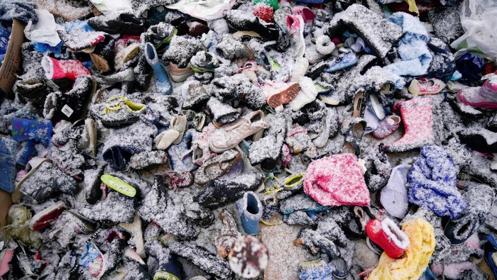 Pengungsi Ukraina Kedinginan di Perbatasan Polandia Snow covered shoes donated for those fleeing the Russian invasion in Ukraine sit on the ground at the border crossing in Medyka, Poland, February 28, 2022. REUTERS/Bryan Woolston TPX IMAGES OF THE DAY