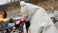 Seorang wanita membungkus tubuhnya dengan selimut saat berada di perbatasan Medyka, Polandia, 28 Februari 2022. REUTERS/Kai Pfaffenbach.