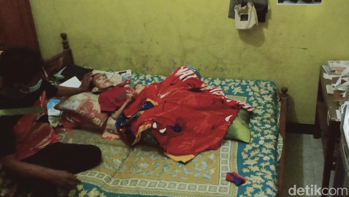 Richei (8) bocah piatu yang menderita infeksi selaput otak asal Klaten tergolek di kamarnya.
