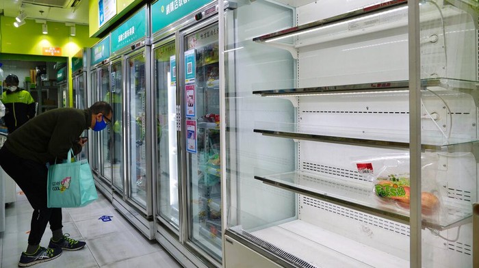 Rumor Lockdown, Warga Hong Kong Serbu Supermarket-Alat Tes COVID A man wearing a face mask looks for food next to the empty shelves of fruit as residents fear a fresh food shortage at a market in Hong Kong, Monday, Feb. 28, 2022. Hong Kong on Monday reported a record-high 34,466 infections, with health authorities saying that a lockdown has not been ruled out as fatalities continued to climb. (AP Photo/Vincent Yu)