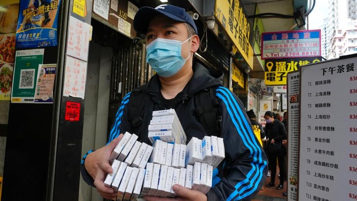 Customers wearing face masks purchase COVID-19 antigen test kits at a market in Hong Kong, Monday, Feb. 28, 2022. (AP Photo/Vincent Yu)