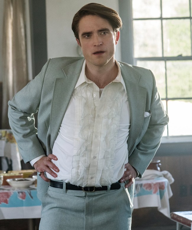 Maju ke 2020, Robert Pattinson berperan sebagai pendeta muda Preston Teagardin di film ‘The Devil All the Time’. Di penampilannya kali ini dia bergaya sleek dan rapi, dengan setelan kemeja serta jas. Foto: Netflix