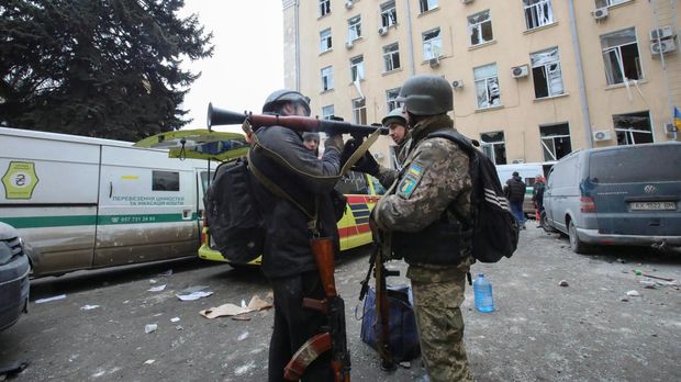 People hold weapons outside the regional administration building, which city officials said was hit by a missile attack, in central Kharkiv, Ukraine, March 1, 2022. REUTERS/Vyacheslav Madiyevskyy