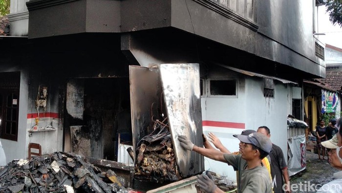 Warga membersihkan warung sembako di Klaten yang terbakar, Selasa (1/3/2022).