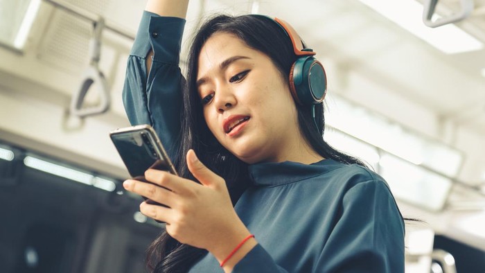 Young woman mobile phone on public train . Urban city lifestyle commuting concept .
