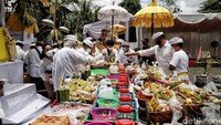 Tampak bebantenan diletakkan di area upacara yang dihiasi oleh janur kuning dan bunga.