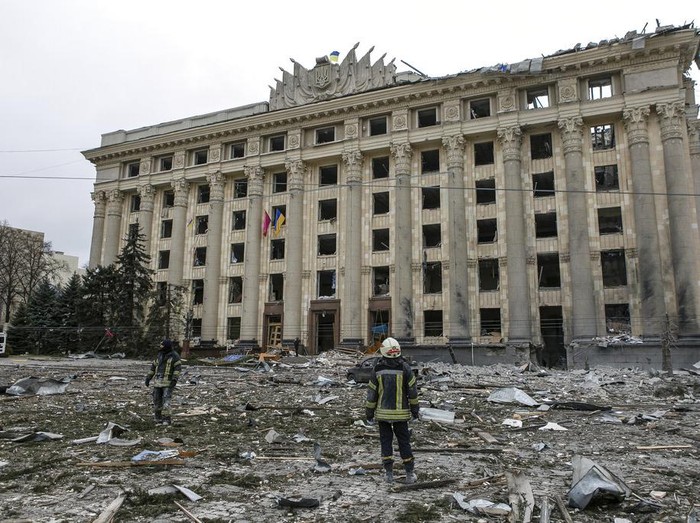A member of the Ukrainian Emergency Service looks at the City Hall building in the central square following shelling in Kharkiv, Ukraine, Tuesday, March 1, 2022. (AP Photo/Pavel Dorogoy)