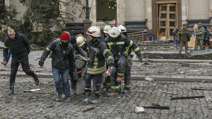 A member of the Ukrainian Emergency Service looks at the City Hall building in the central square following shelling in Kharkiv, Ukraine, Tuesday, March 1, 2022. (AP Photo/Pavel Dorogoy)