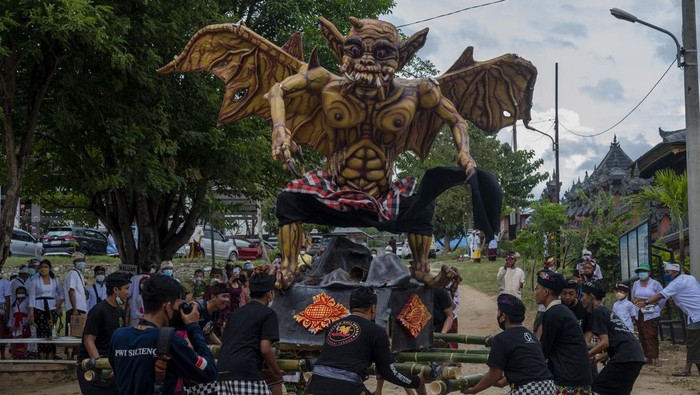 Seorang Serati memercikkan air suci kepada umat sebelum pawai Ogoh-ogoh terbatas di Pura Agung Wanakertha Jagatnatha, Palu, Sulawesi Tengah, Rabu (2/3/2022). Pawai Ogoh-ogoh yang merupakan rangkaian kegiatan menjelang Hari Raya Nyepi itu terpaksa dilaksanakan secara terbatas di dalam kawasan pura dan dihadiri perwakilan banjar umat saja untuk menghindari penularan COVID-19 yang kasusnya meningkat dalam sebulan terakhir di wilayah ini. ANTARA FOTO/Basri Marzuki/rwa.