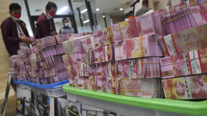 PENGUNGKAPAN KEJAHATAN UANG PALSU Petugas kepolisian menata barang bukti mata uang rupiah palsu saat rilis pengungkapan kejahatan mata uang palsu di Bareskrim Mabes Polri, Jakarta, Selasa (1/3/2022). Direktorat Tindak Pidana Ekonomi dan Khusus (Dittipideksus) Bareskrim Polri berhasil mengungkap kejahatan uang palsu dengan barang bukti berupa 494.904 lembar mata uang rupiah pecahan Rp100.000 dan mata uang dolar pecahan USD 100 serta mengamankan 12 orang tersangka di dua wilayah berbeda. ANTARA FOTO/Galih Pradipta/rwa.