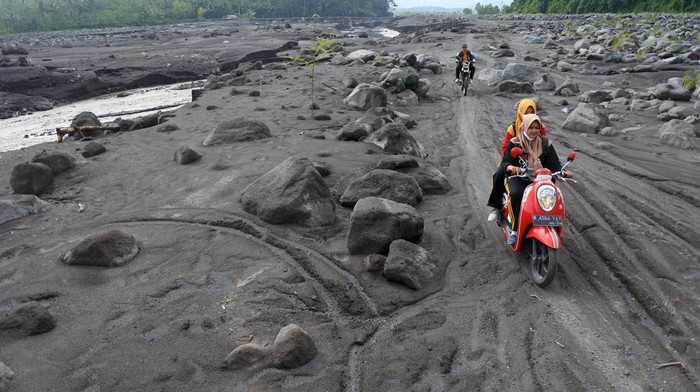 PERJUANGAN GURU DI LERENG GUNUNG SEMERU Guru SDN Jugosari 03 Eri Eliyawati, Lilik Kusnilawati dan Purnomo Candra Ronanta menyusuri pinggiran Sungai Regoyo di Desa Jugosari, Candipuro, Lumajang, Jawa Timur.