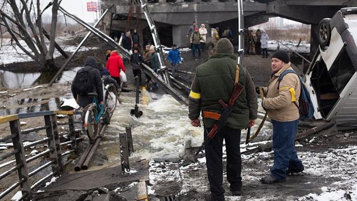Susah Payah Warga Ukraina Kabur dari Perang IRPIN, UKRAINE - MARCH 1: People cross the destroyed bridge across the Irpin river on March 1, 2022 in Irpin, Ukraine. Russian forces continued to advance on the Ukrainian capital of Kyiv as their invasion of its western neighbor entered its sixth day. Intense battles also continue in Ukraine's other major cities. (Photo by Anastasia Vlasova/Getty Images)