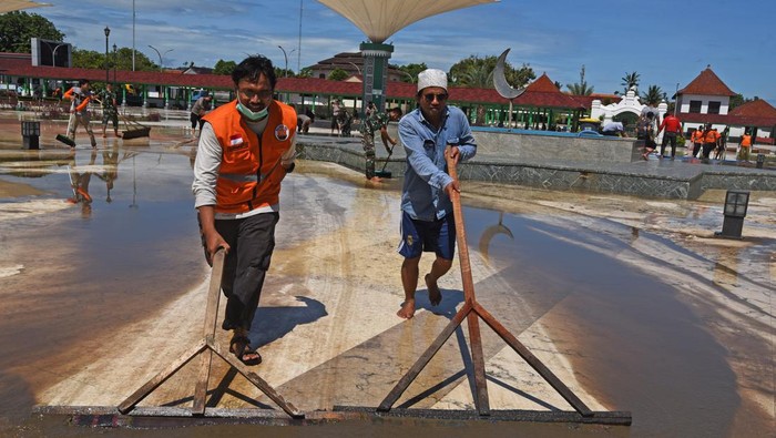 Banjir Surut, Relawan Gotong Royong Bersihkan Masjid Kesultanan Banten Sejumlah relawan bergotong royong membersihkan halaman Masjid Kesultanan Banten usai banjir menyusut di Kasemen, Serang, Banten, Kamis (3/3/2022). ANTARA FOTO/Asep Fathulrahman/wsj.