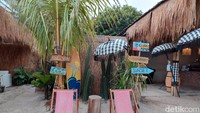 Saat masuk ke dalam, traveler bisa melihat bahwa tempat ini ditata sedemikian rupa supaya suasana pantainya terasa. Semua lahannya beralaskan pasir, lengkap juga dengan pohon kelapa di tengahnya. Juga ada bangku pantai yang bisa digunakan wisatawan untuk berfoto ala pantai.