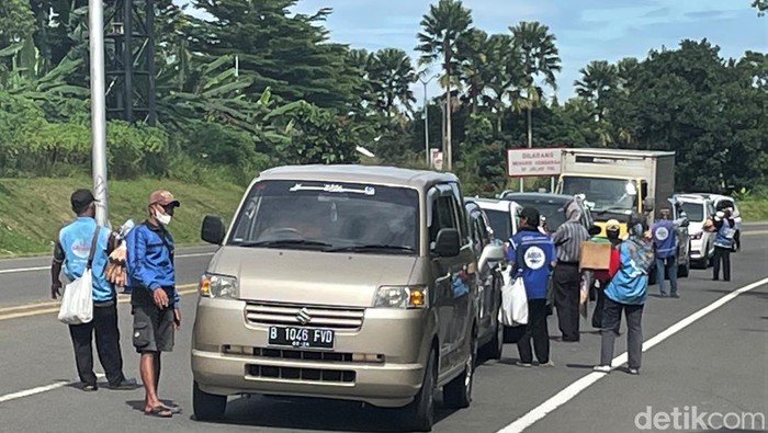 Ramainya kawasan Puncak, Bogor, saat liburan dimanfaatkan para pedagang asongan untuk meraup cuan. Beragam dagangan dijajakan kepada pengendara yang melintas.