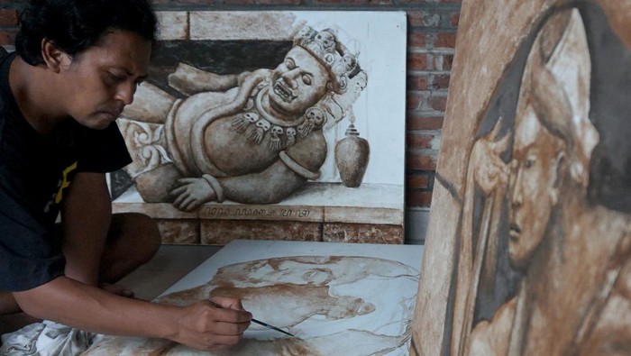 Unik dan Artistik, Ini Dia Lukisan dari Ampas Kopi Seniman lukis cethe Adhitya Kreshna melukis gambar wajah orang menggunakan bahan pewarna endapan kopi di rumah galeri miliknya, Tulungagung, Jawa Timur, Rabu (2/3/2022). Karya lukis cethe bertema