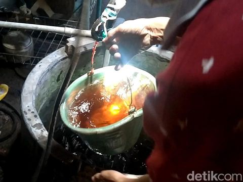 Warga Kelurahan Simbeng Kulon Pekalongan menunjukkan air yang menghitam.