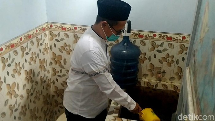 Warga Kelurahan Simbeng Kulon Pekalongan menunjukkan air yang menghitam.