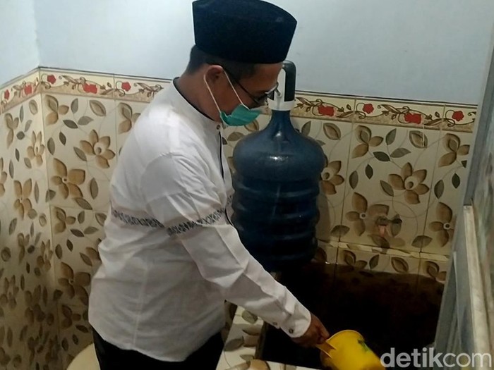 Warga Kelurahan Simbeng Kulon Pekalongan menunjukkan air yang menghitam.