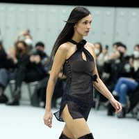 Gaya seksi tersebut lalu disempurnakan dengan sepasang high-knee boots lateks yang mengilap. Sementara itu untuk riasan, wajah Bella berpulas minim makeup yang minimalis sehingga lebih menonjolkan kecantikan naturalnya. (Foto: Francois Durand/Getty Images)