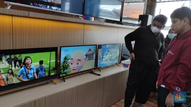 Calon pembeli melihat tv yang dijual disalah satu toko elektronik di Jakarta,  Jumat (4/3/2022). Pemerintah akan segera menghentikan siaran TV analog mulai bulan depan. Saat ini berbagai merek TV berlomba memasarkan produknya dengan persaingan harga. (CNBC Indonesia/Andrean Kristianto)