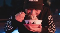 Penggemar berat mie instan, ini pose seru Doni saat melahap mie instan di lesehan dengan pakaian serba mahalnya. Ia juga tampak menambahkan saus dan kecap sebelum menyantap mie instan. Foto: Instagram @donisalmanan