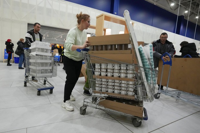 People wait in a line to enter the IKEA store at the outskirts of St. Petersburg, Russia, Thursday, March 3, 2022. IKEA is closing its stores and pausing all sourcing in Russia and Belarus from Friday, March 4. 