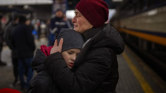 A couple says goodbye before she boards on a train bound for Lviv at the Kyiv station, Ukraine, Thursday, March 3. 2022.