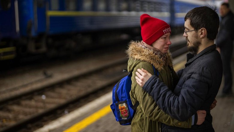 A couple says goodbye before she boards on a train bound for Lviv at the Kyiv station, Ukraine, Thursday, March 3. 2022.