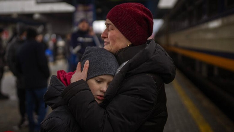 Stanislav, 40, says goodbye to his son David, 2, and his wife Anna, 35, on a train to Lviv at the Kyiv station, Ukraine, Thursday, March 3. 2022. Stanislav is staying to fight while his family is leaving the country to seek refuge in a neighbouring country. (AP Photo/Emilio Morenatti)