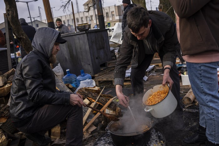 Intip Dapur Umum Darurat di Tengah Perang Ukraina Relawan mendirikan dapur umum di luar stasiun kereta Lviv, Ukraina. Makanan dibuat untuk para pengungsi akibat invasi Rusia.