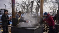 Bumbu masak ditaburkan dalam masakan yang diolah di dapur umum di di luar stasiun Lviv, Ukraina barat, Kamis (3/3/2022). Rusia belum menunjukan penurunan serangan ke Ukraina setelah sepekan menyerbu negara tetangganya itu. 